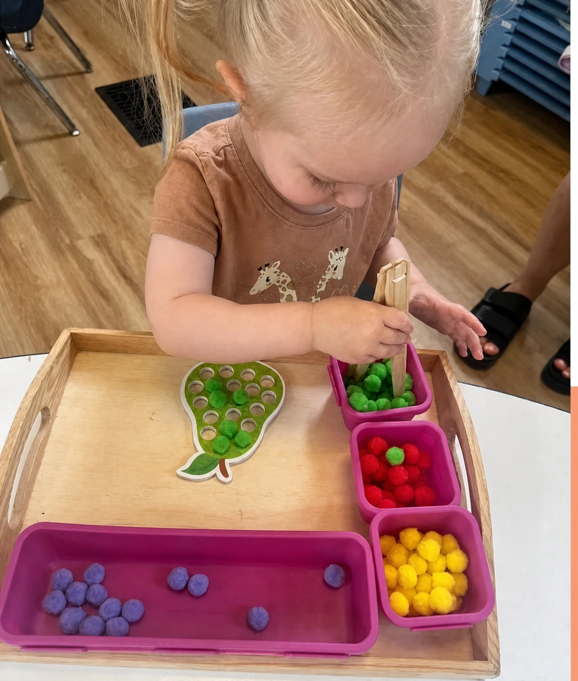 A toddler sorting colourful counters during a hands-on activity.
